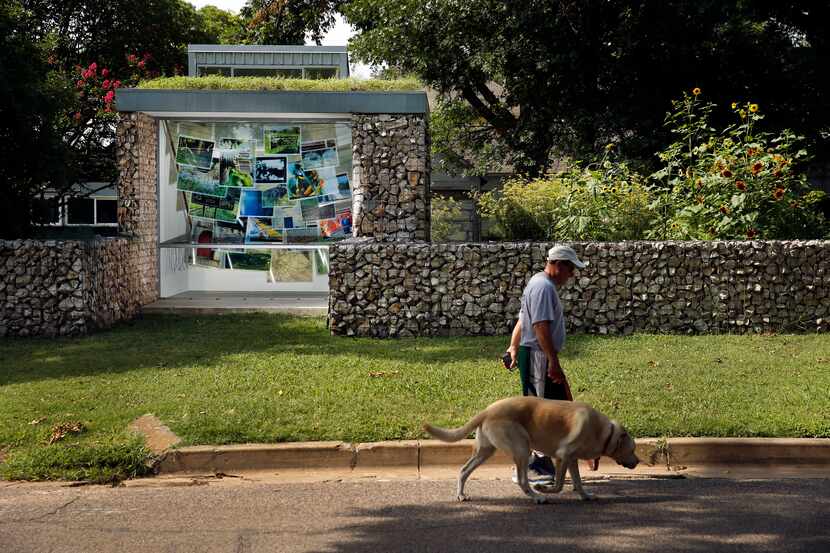 A man walks his dog past the Blind Alley art gallery.
