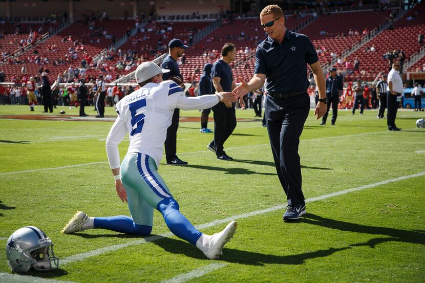 Cowboys head coach Jason Garrett greets kicker Dan Bailey (5) as the Cowboys stretch before...