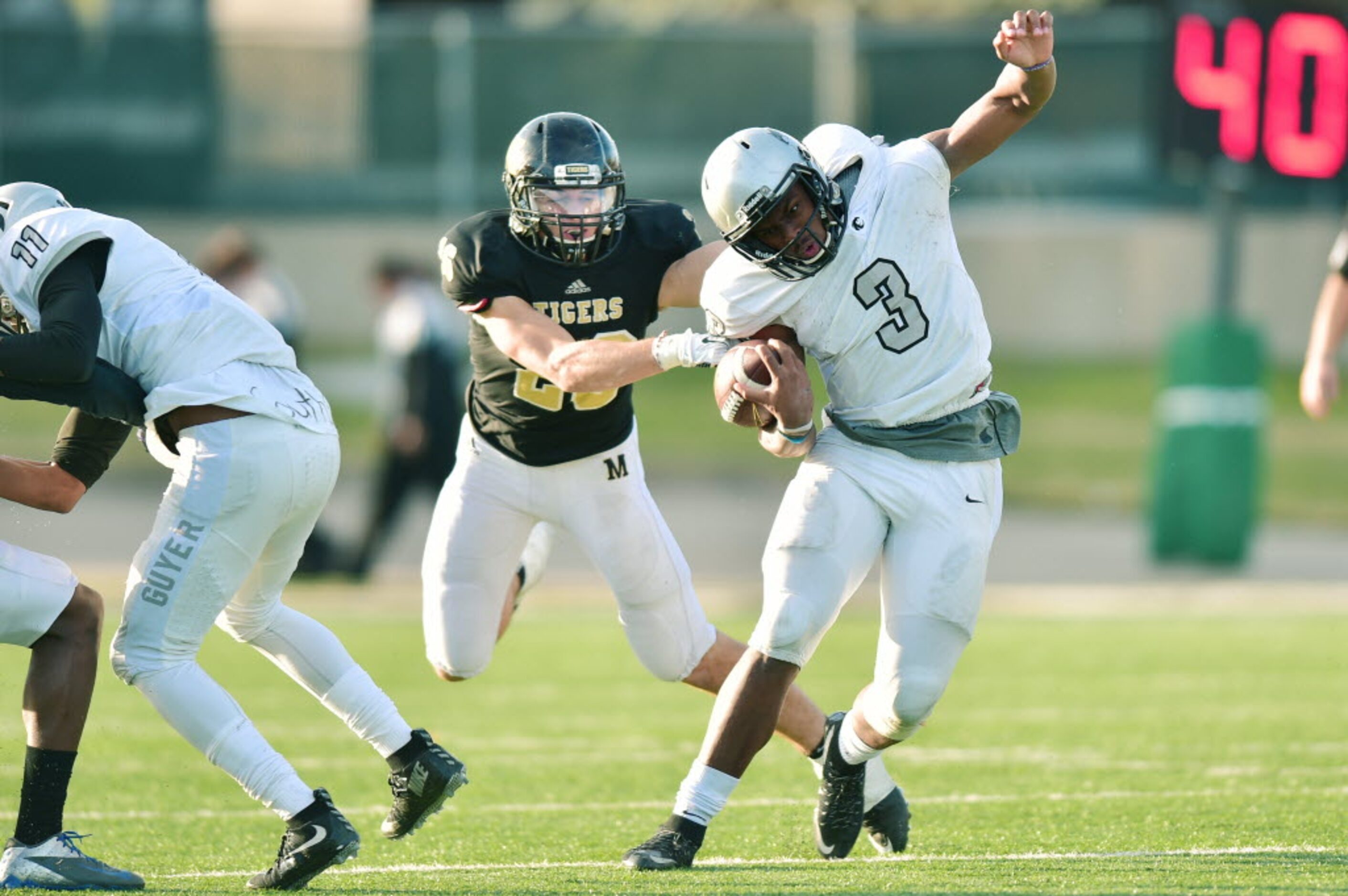 Guyer junior quarterback Shawn Robinson (3) breaks away from Mansfield senior linebacker...