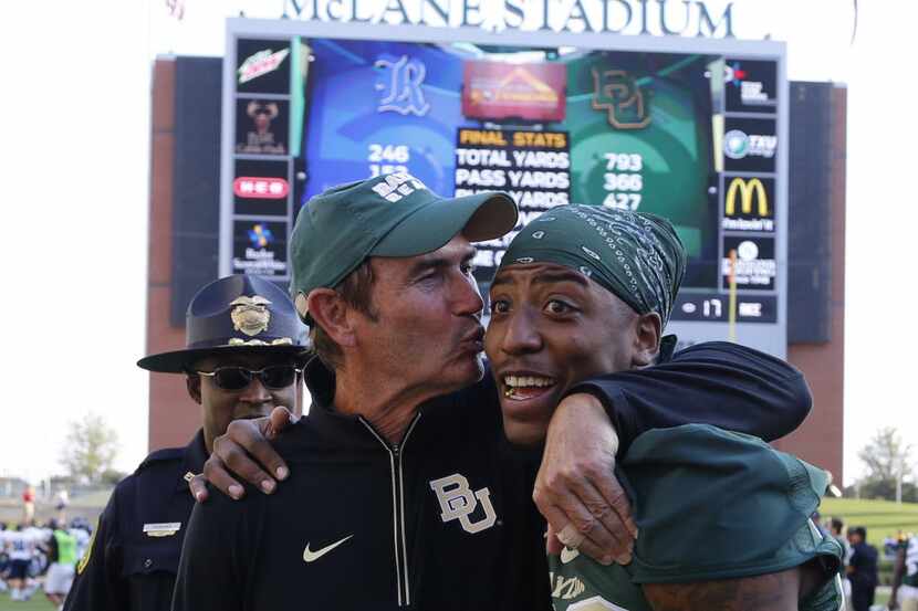 Baylor head coach Art Briles, left, gives safety Orion Stewart (28) a kiss following their...