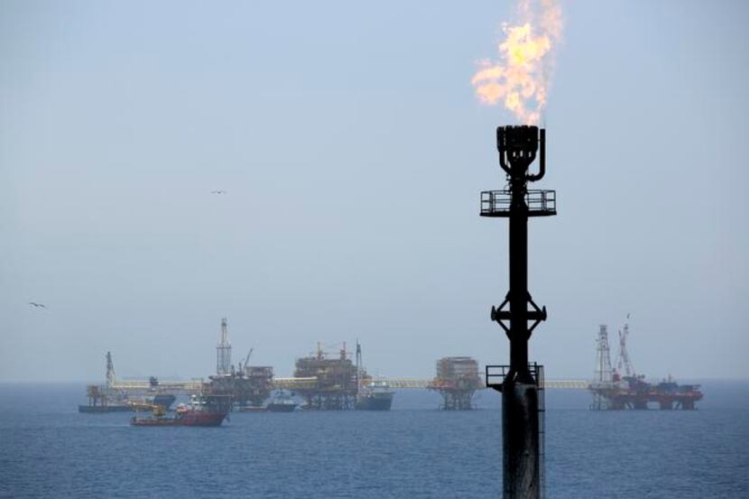 
Gas is flared from a tower on an oil drilling rig operated by Pemex in an oilfield off the...
