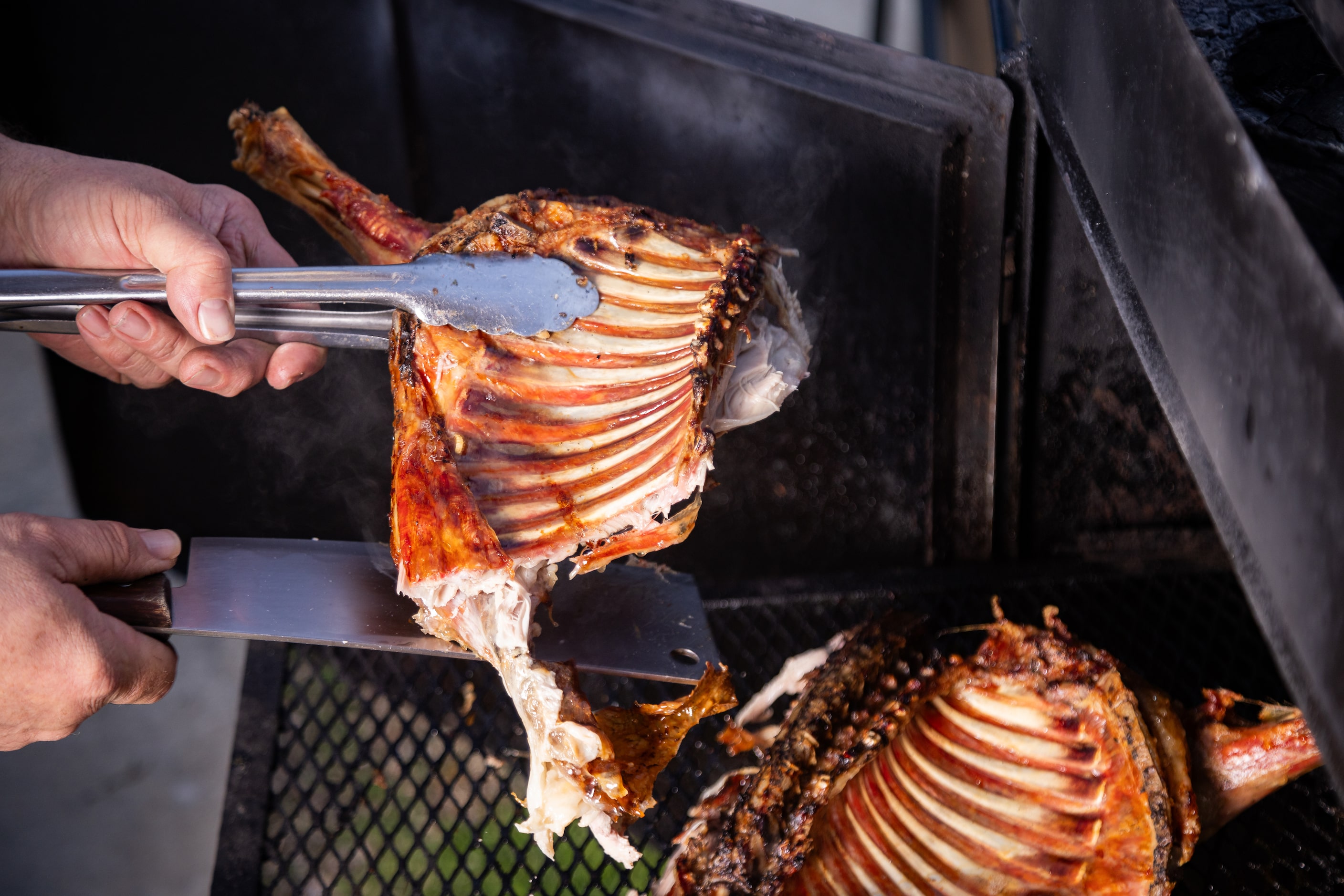 Montemayor, a native of Monterrey and owner of Tacos Lalo, breaks apart the cabrito to after...