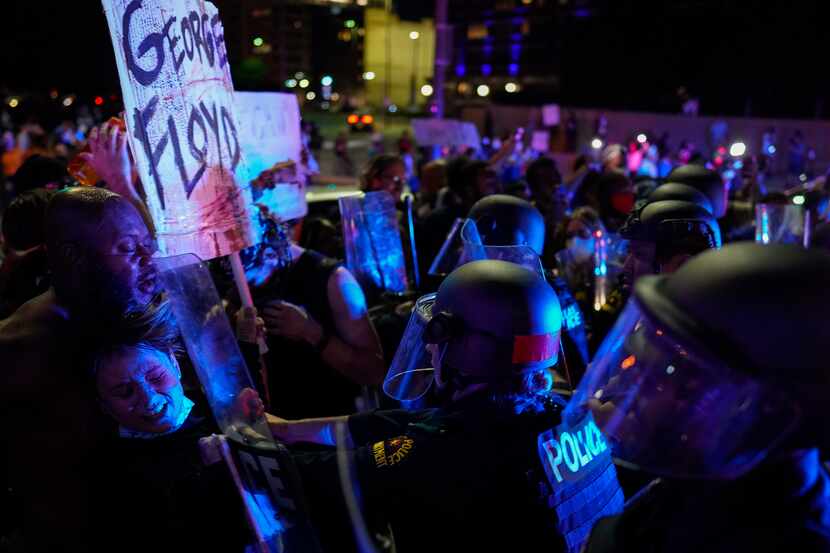 Dallas police clash with protesters at the corner of of Griffin and Young Streets as they...