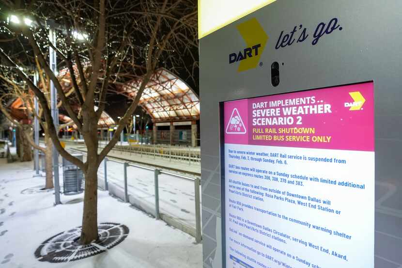 A message board shows a notice of transit agency suspensions of service at the DART rail...
