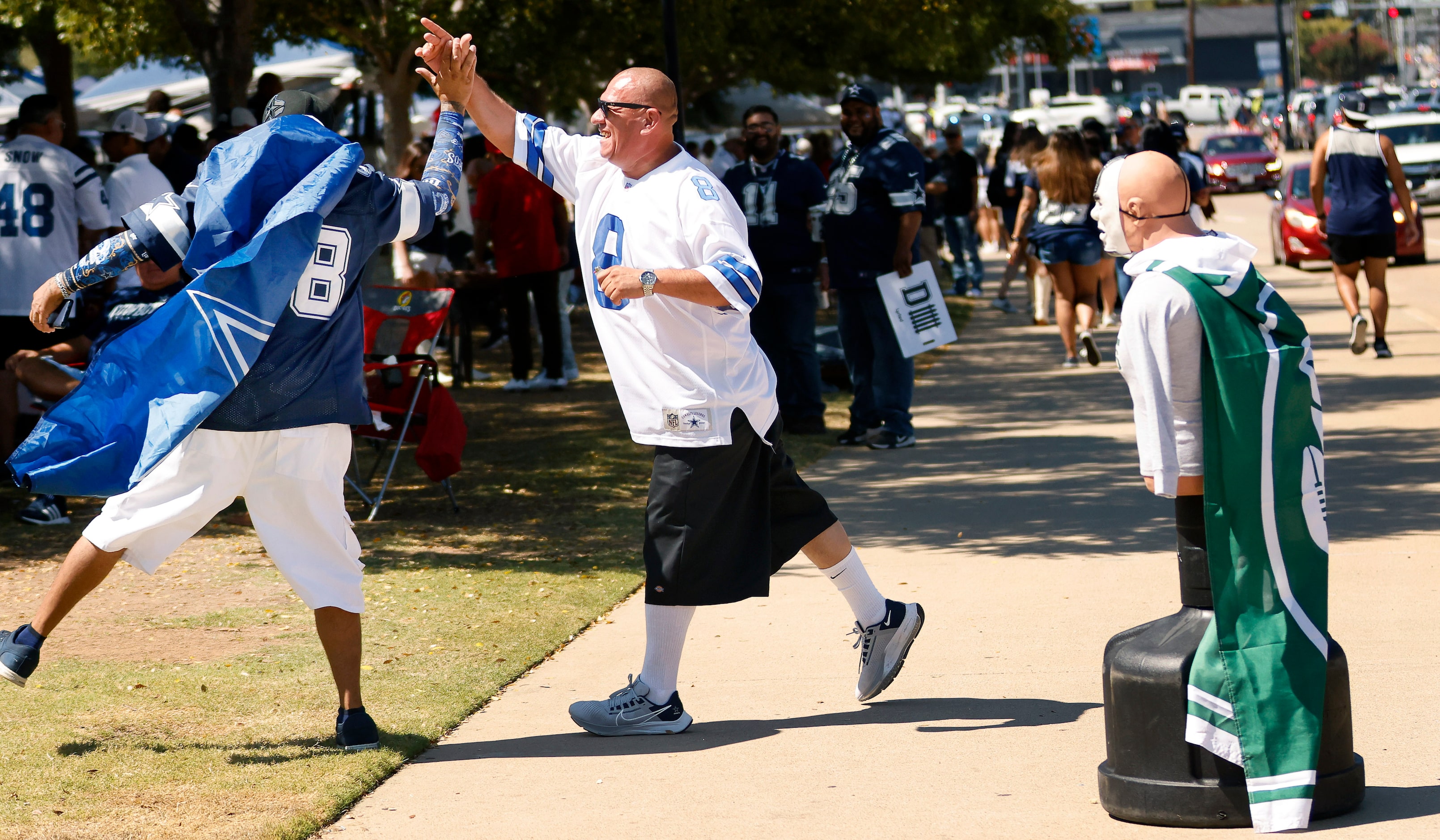 Dallas Cowboys fan Eddie Marquez of Irving (center) receives a high-five from Jimmy...