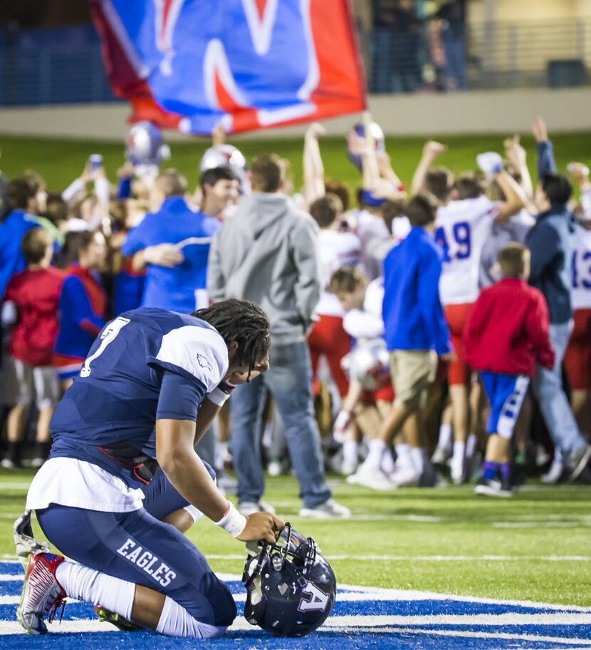 Allen quarterback Seth Green (7) kneels at midfield as Westlake celebrate their 23-17...