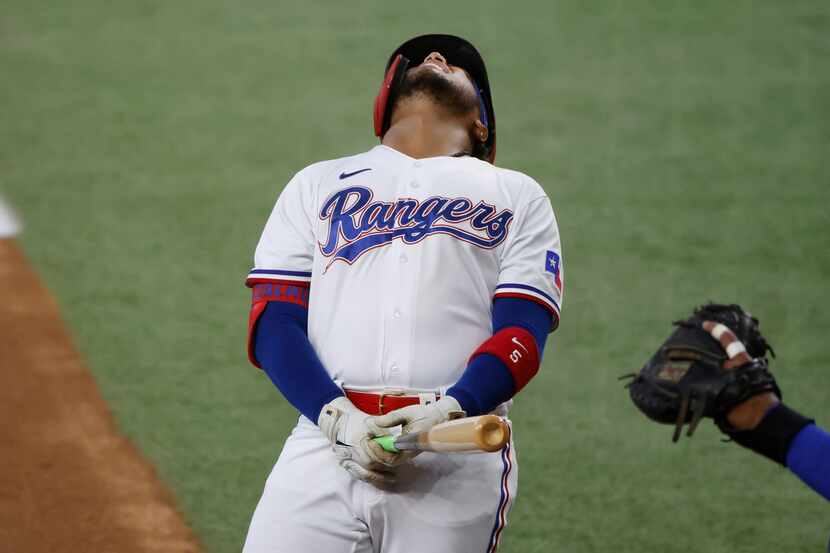 Texas Rangers designated hitter Willie Calhoun reacts after being hit on the left wrist by a...