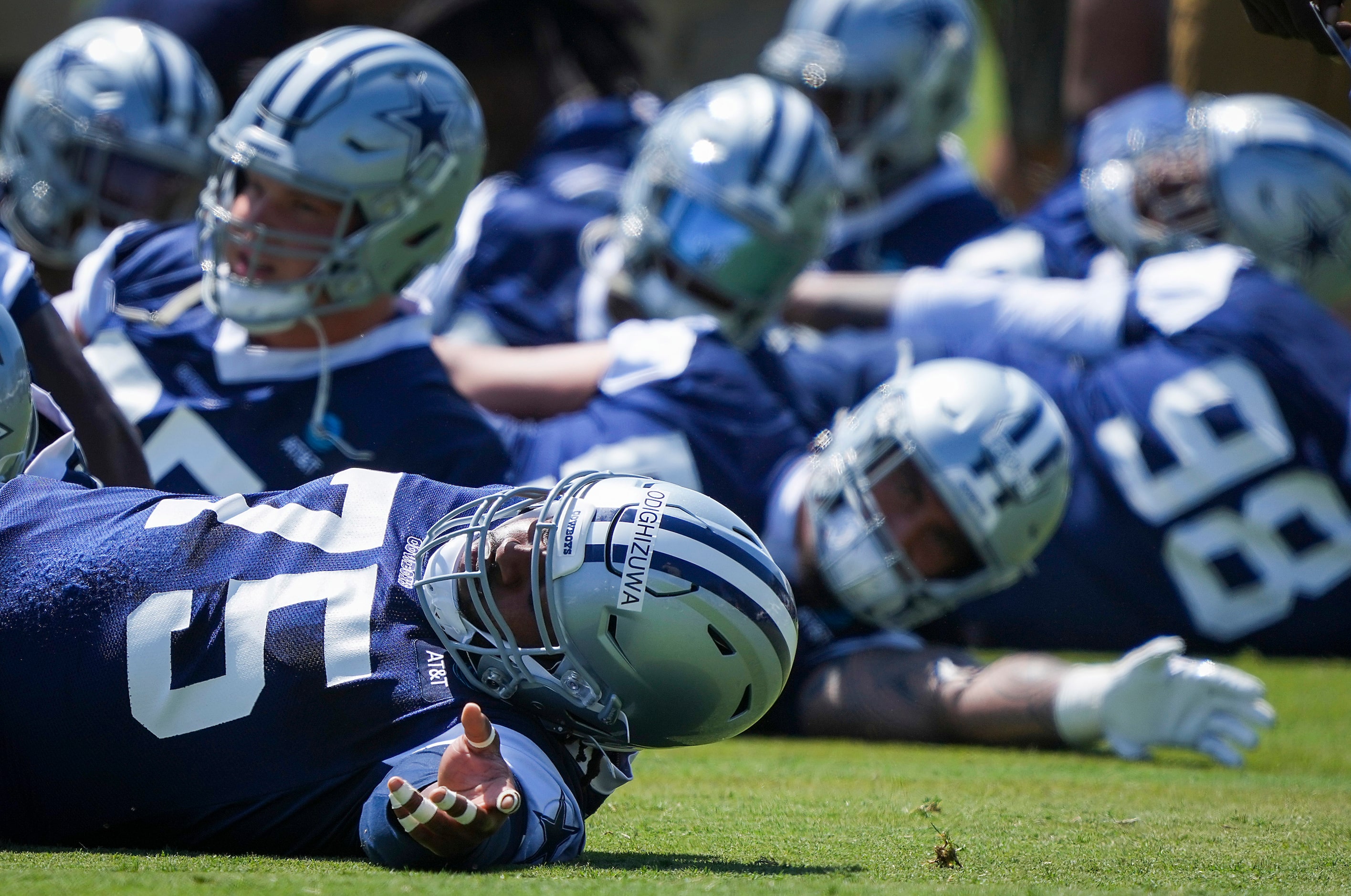 Dallas Cowboys defensive tackle Osa Odighizuwa (75) stretches with teammates during the...