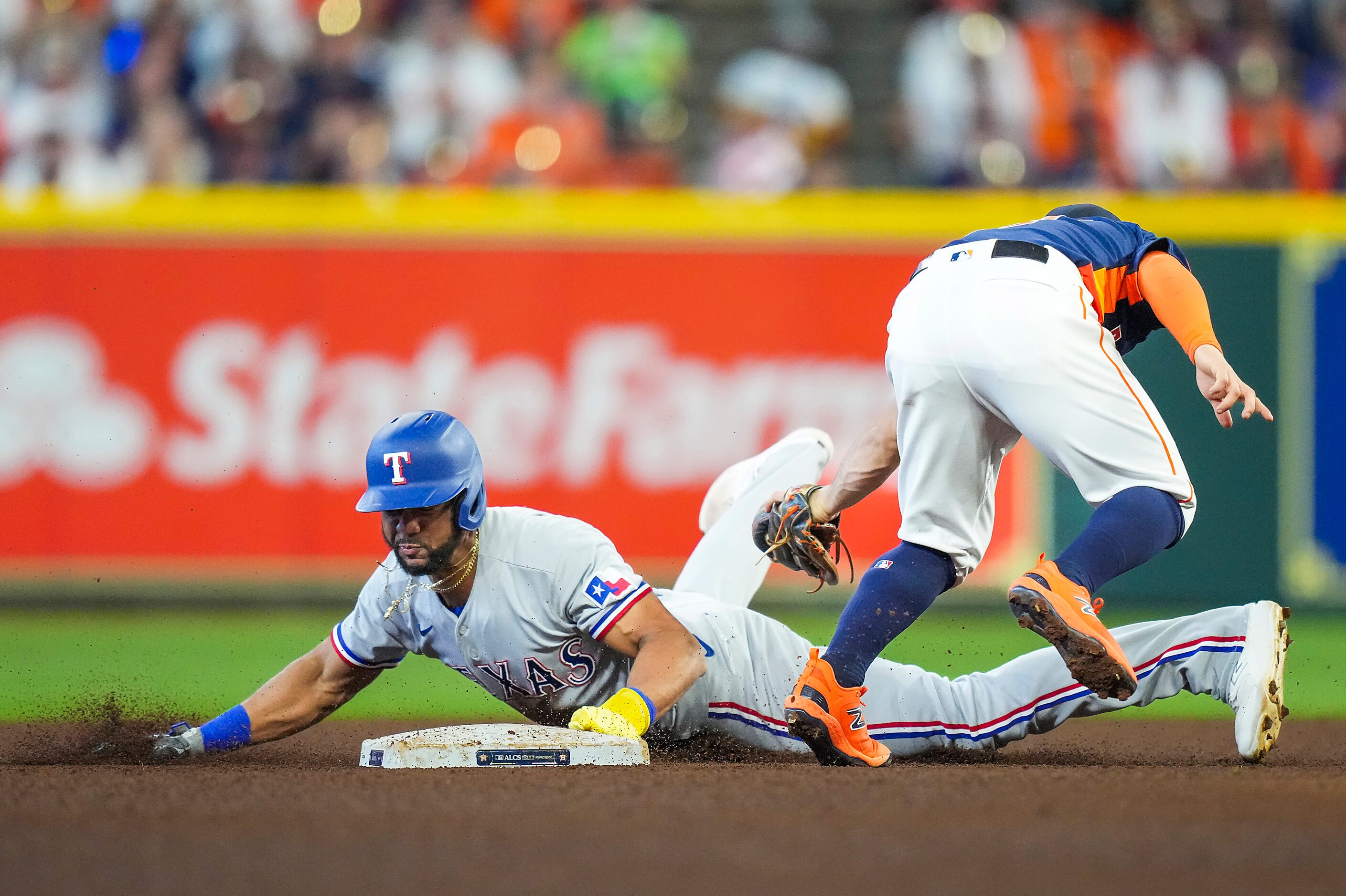 Texas Rangers center fielder Leody Taveras steals second base ahead of the tag from Houston...