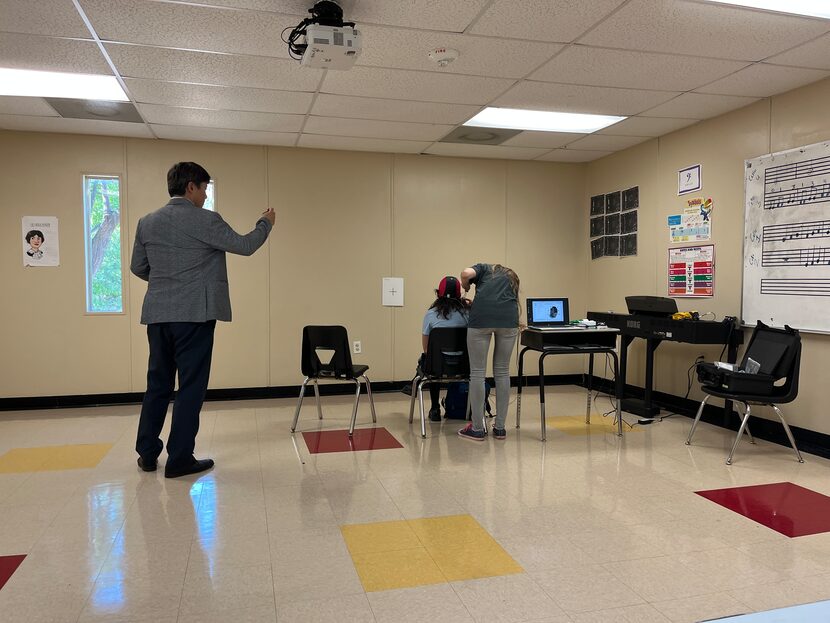 Student sitting in a chair in a school classroom undergoing a study about music's effect on...