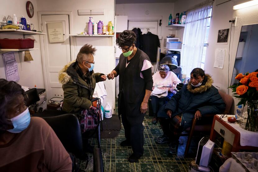 Earnestine Tarrant fist bumps with Sharon Curtis at her hair salon in South Dallas on her...