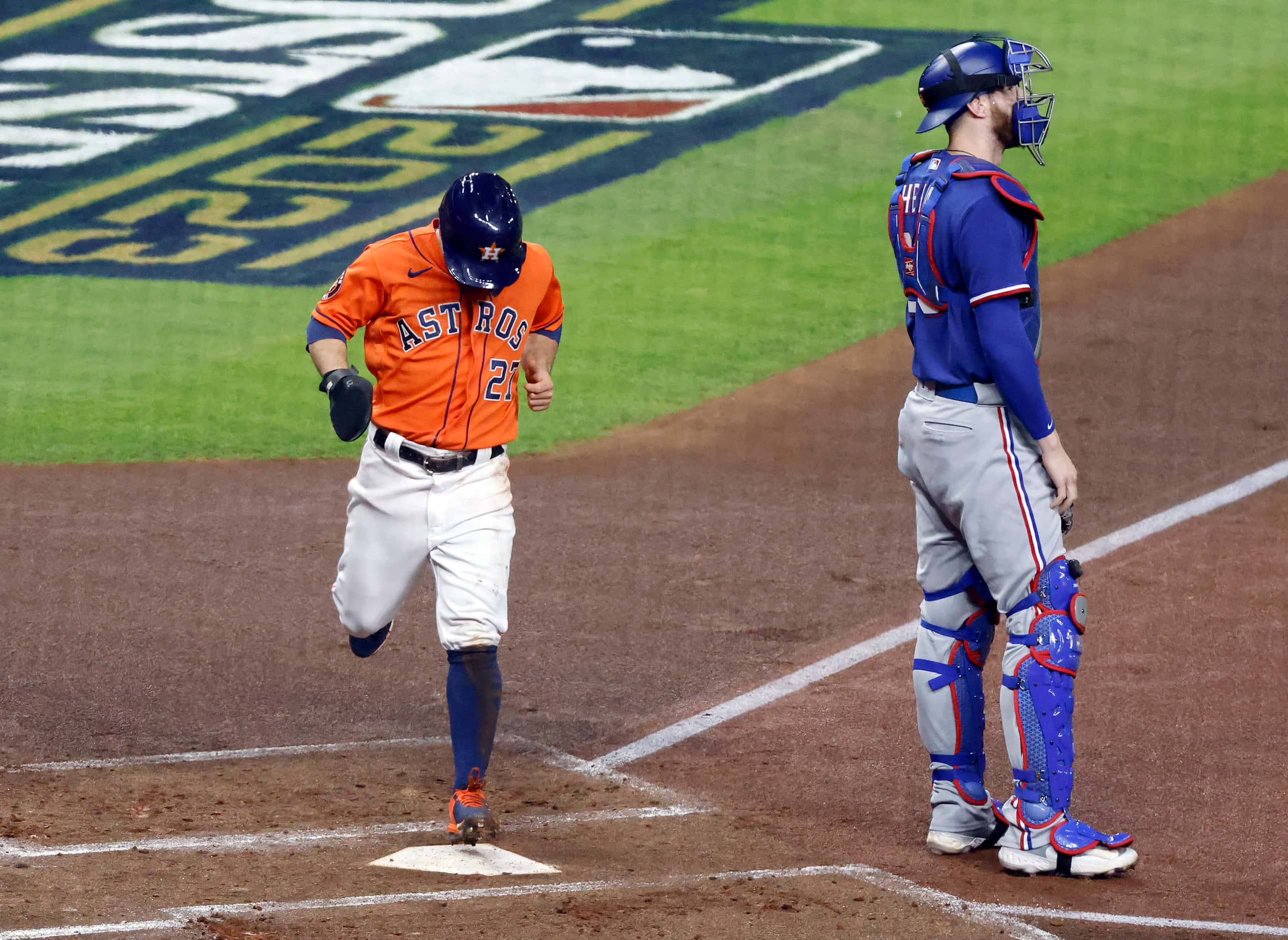 Houston Astros Jose Altuve (27) crosses home plate on a first inning RBI single by Yordan...