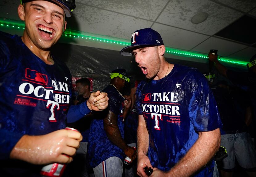Texas Rangers first baseman Nathaniel Lowe, left, celebrates with teammates after clinching...