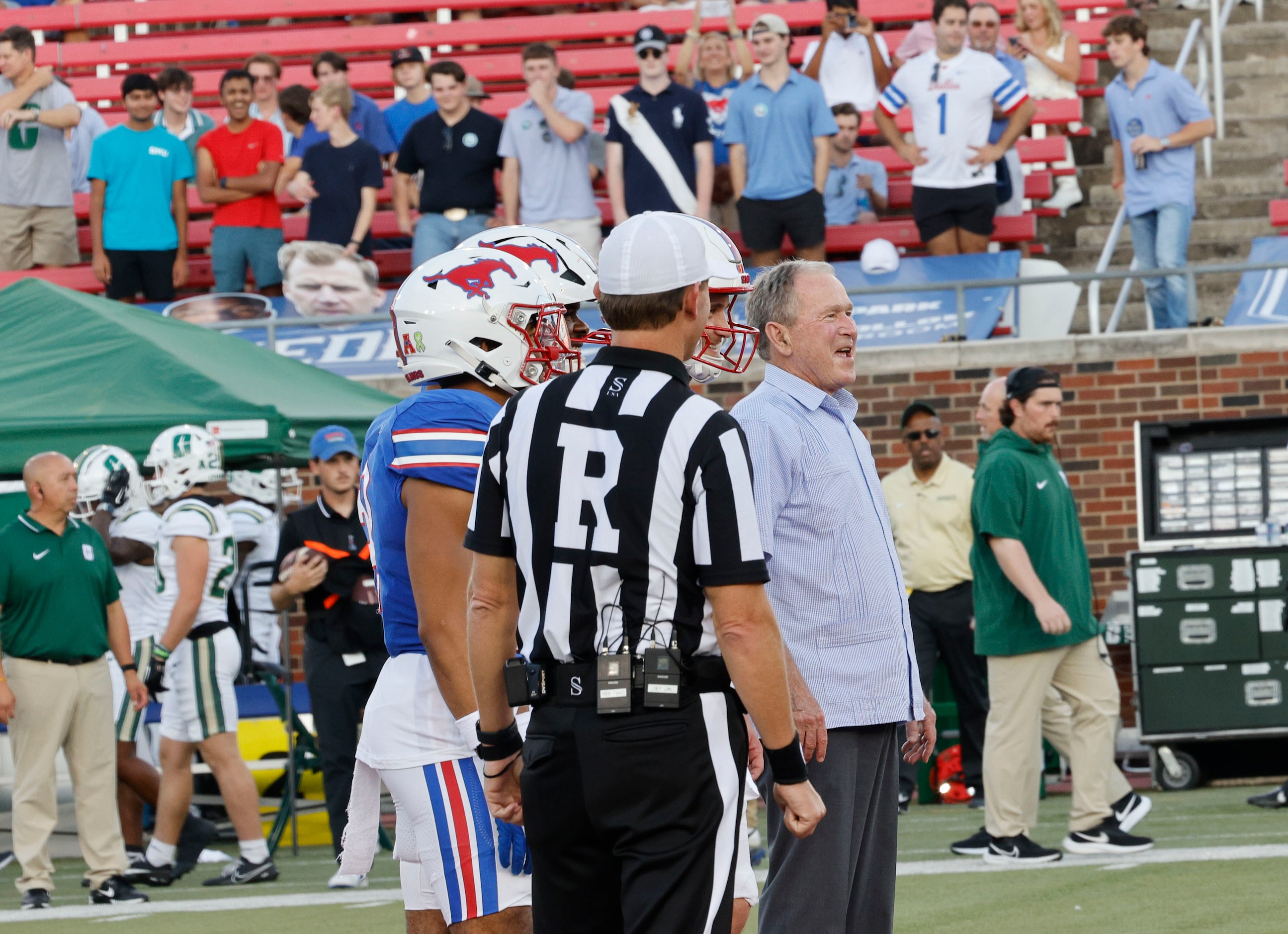 Former President George W. Bush, left, smiles after he attended the coin toss before an NCAA...