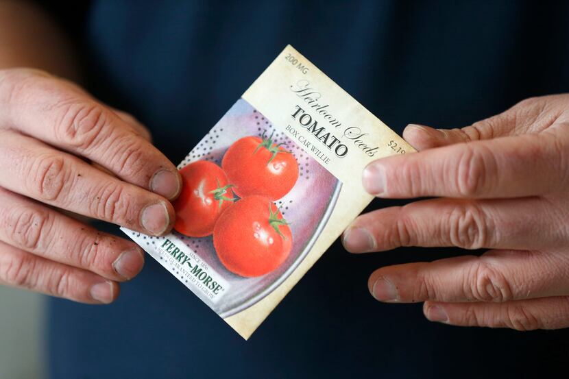 Horticulturalist Daniel Cunningham holds a package of tomato seeds.