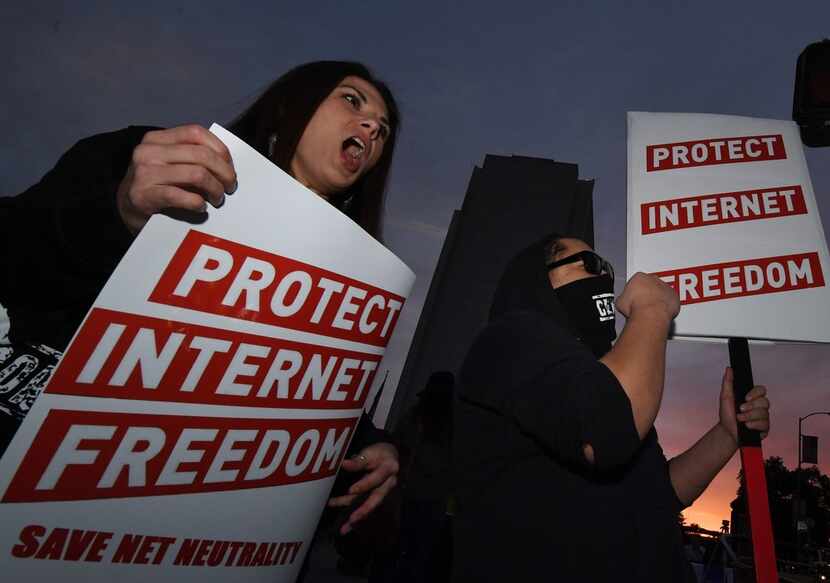 People protest during a rally to 'Protect Net Neutrality' as they voice their opposition to...