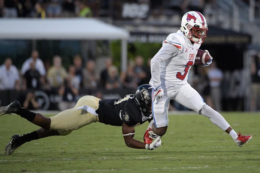 SMU wide receiver James Proche (3) is tackled by Central Florida defensive lineman Brendon...