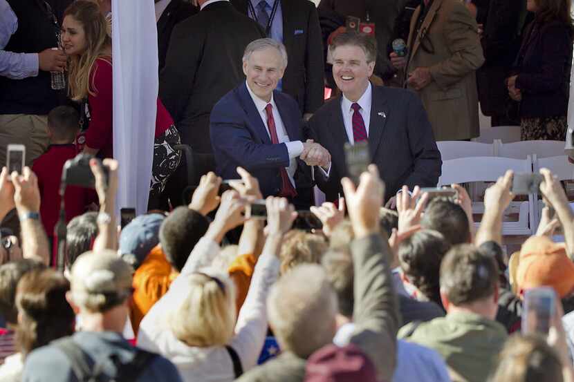 Texas Governor Greg Abbott and Lt. Gov. Dan Patrick greet the crowd from the parade stand...