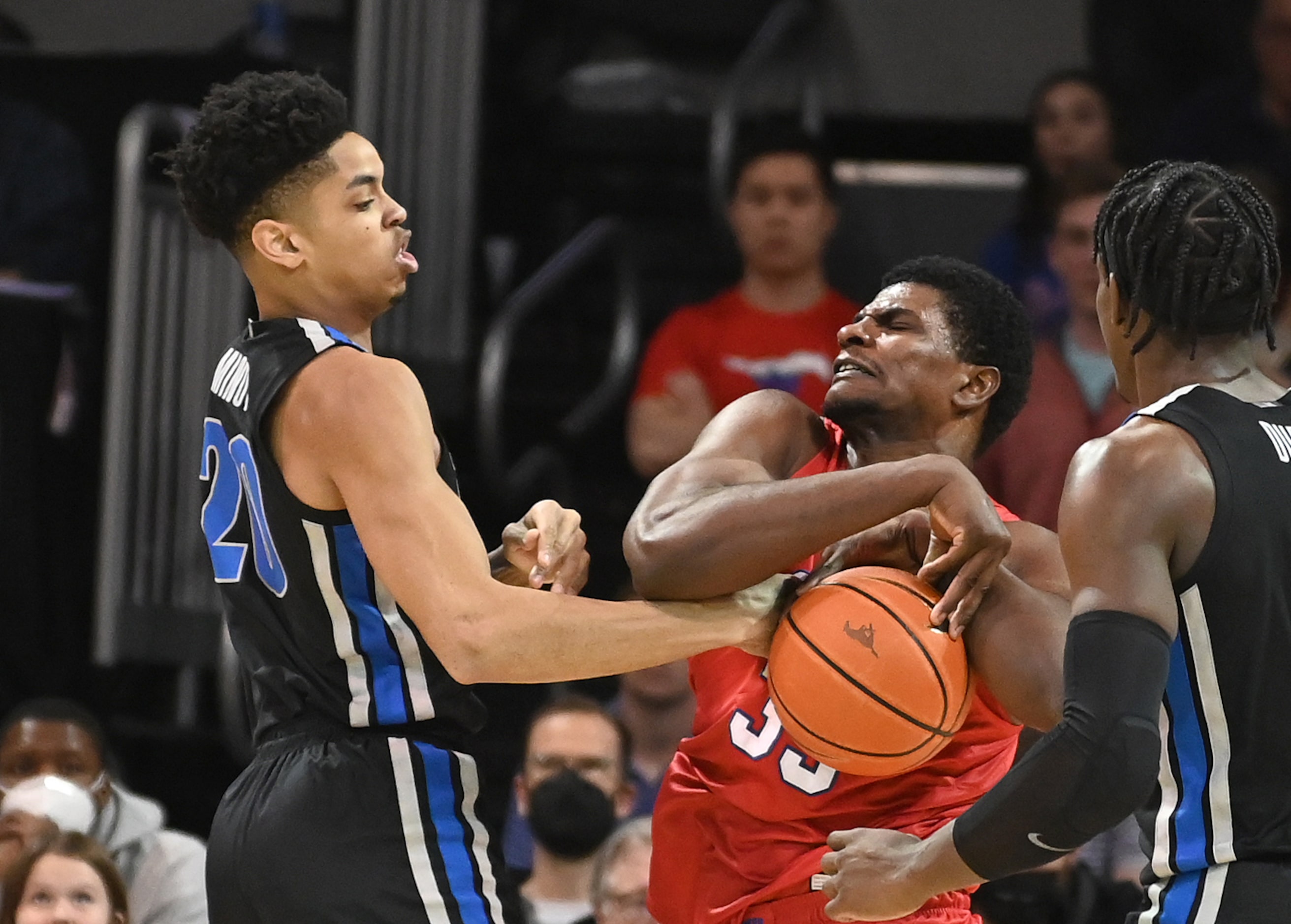 SMU forward Franklin Agunanne (33) holds onto a rebound as he’s contested by Memphis forward...