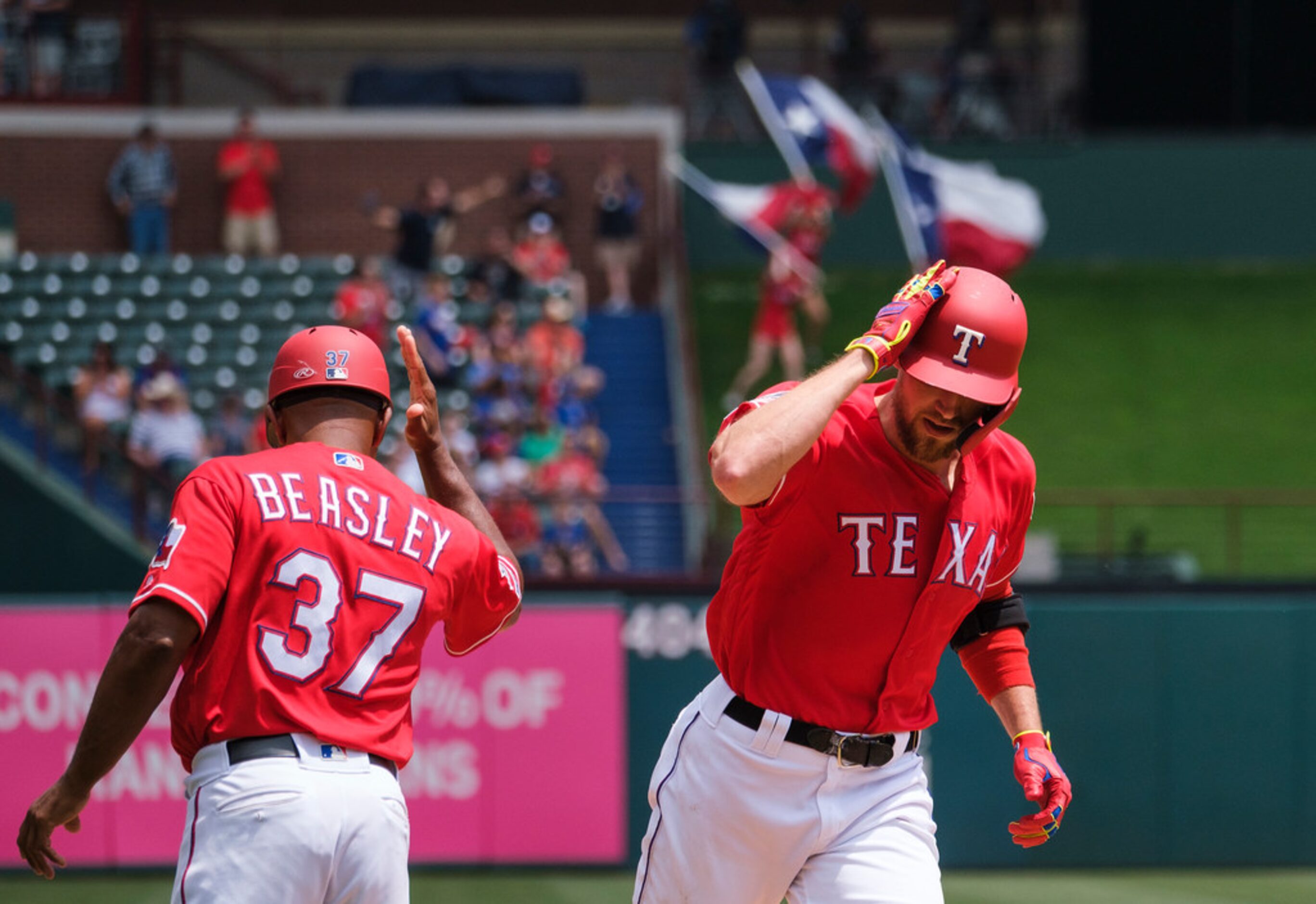 Texas Rangers designated hitter Hunter Pence celebrates with third base coach Tony Beasley...