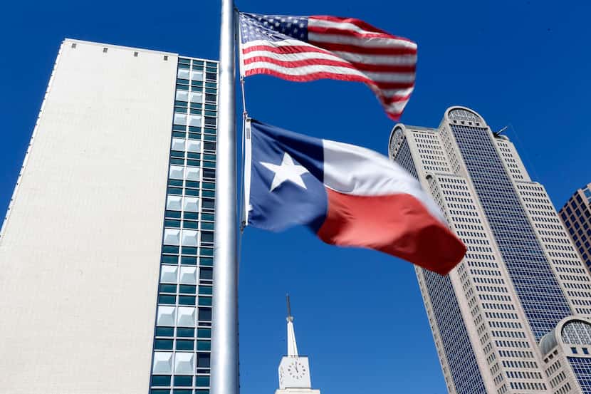 The U.S. and Texas flags fly at half staff above The Dallas Morning News building.