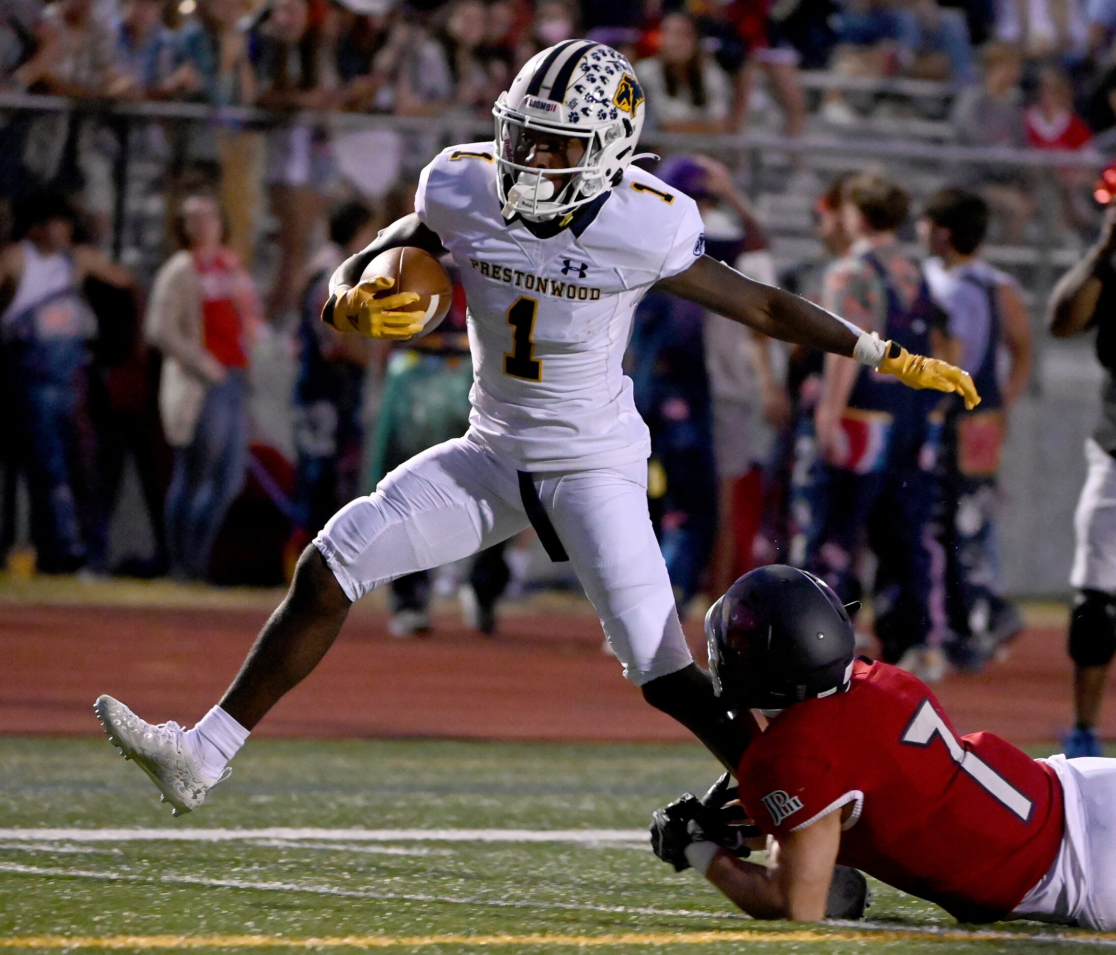 Prestonwood's Nathan Stafford (1) runs through a tackle attempt by John Paul II's Ben Boland...