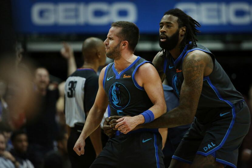 Dallas Mavericks center DeAndre Jordan, right, holds onto guard Jose Juan Barea after Barea...