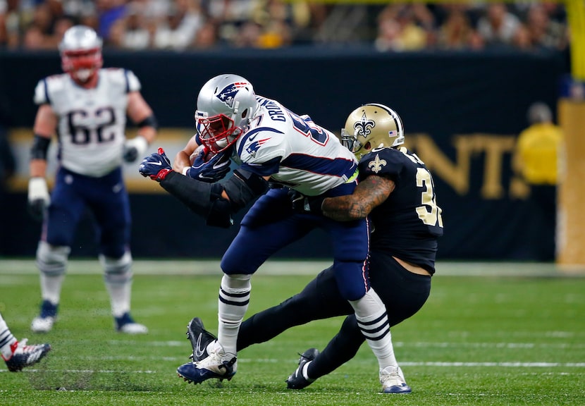 New England Patriots tight end Rob Gronkowski tries to break the tackle by New Orleans...