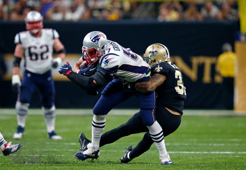 New England Patriots tight end Rob Gronkowski tries to break the tackle by New Orleans...