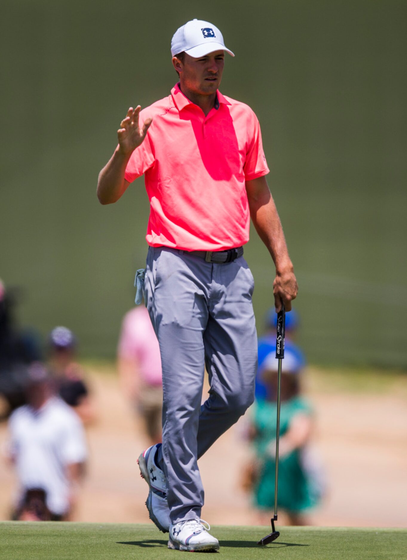 Jordan Spieth waves to fans after taking a shot on hole 1 during round 4 of the AT&T Byron...