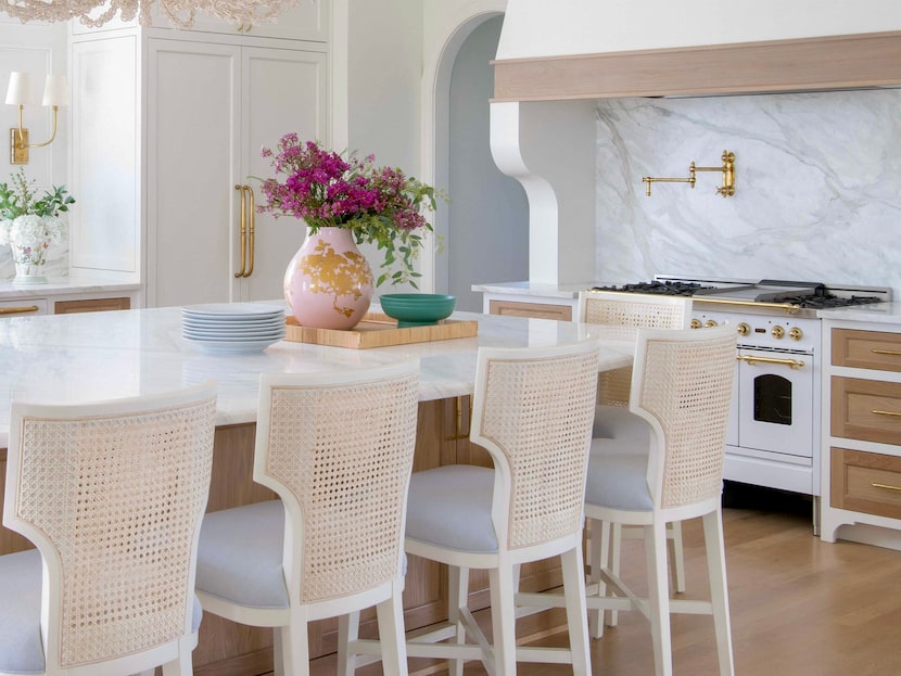 A white kitchen features warm wood paneling on the cabinetry.