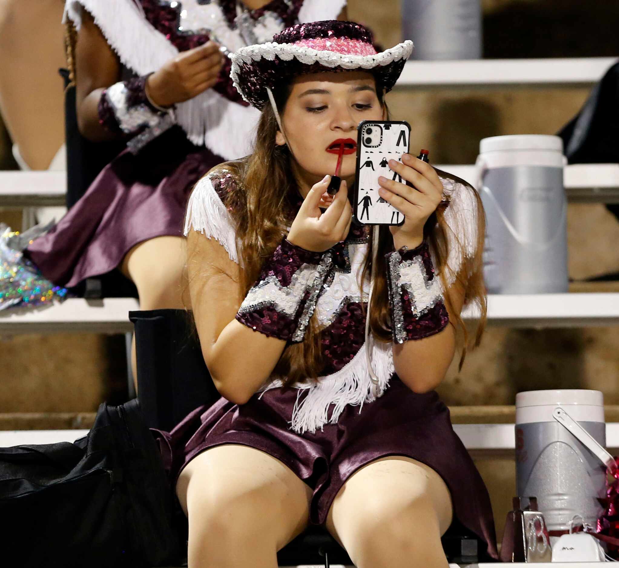 A Lewisville drill team member adjusts her lipstick during a break in the action in the...