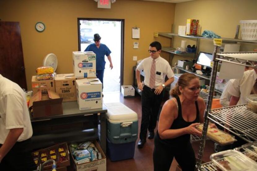 
 bold Volunteers at  /bold Frisco Family Services’ food pantry process a donation from a...