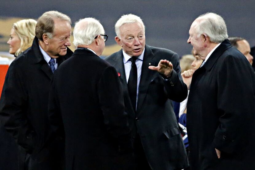 Dallas Cowboys owner Jerry Jones (center) talks with other men before a game against the...