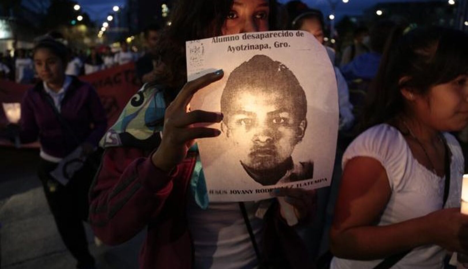 Una mujer marcha por la Ciudad de México para denunciar la desaparición de los 43...