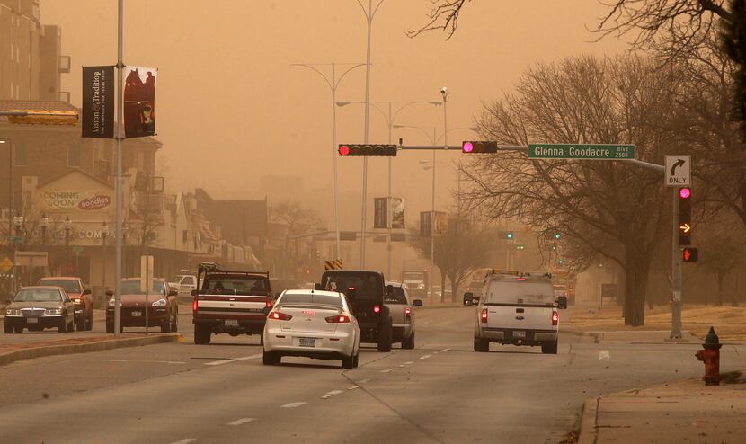 Cars navigate along University Avenue during a dust storm in Lubbock, Texas, Wednesday, Dec....