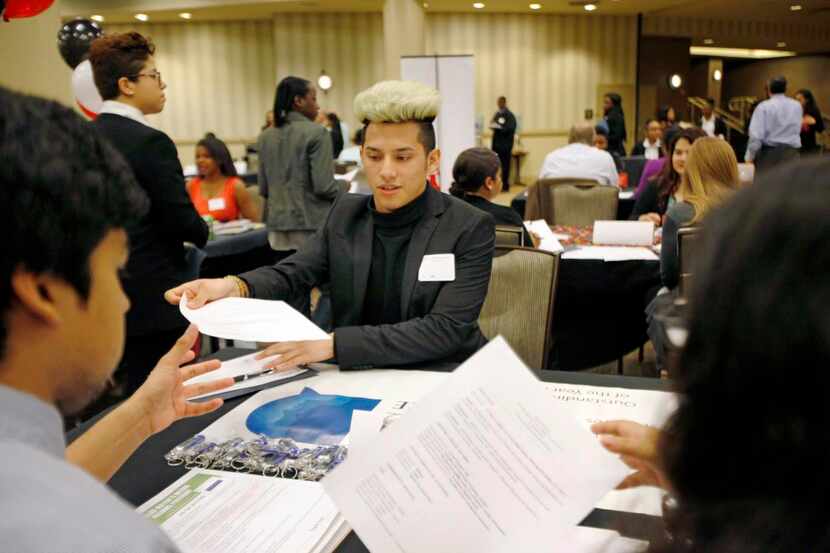 
Maceo Smith New Tech student, Jesus Rosas, 17, hands his resume to representatives of the...