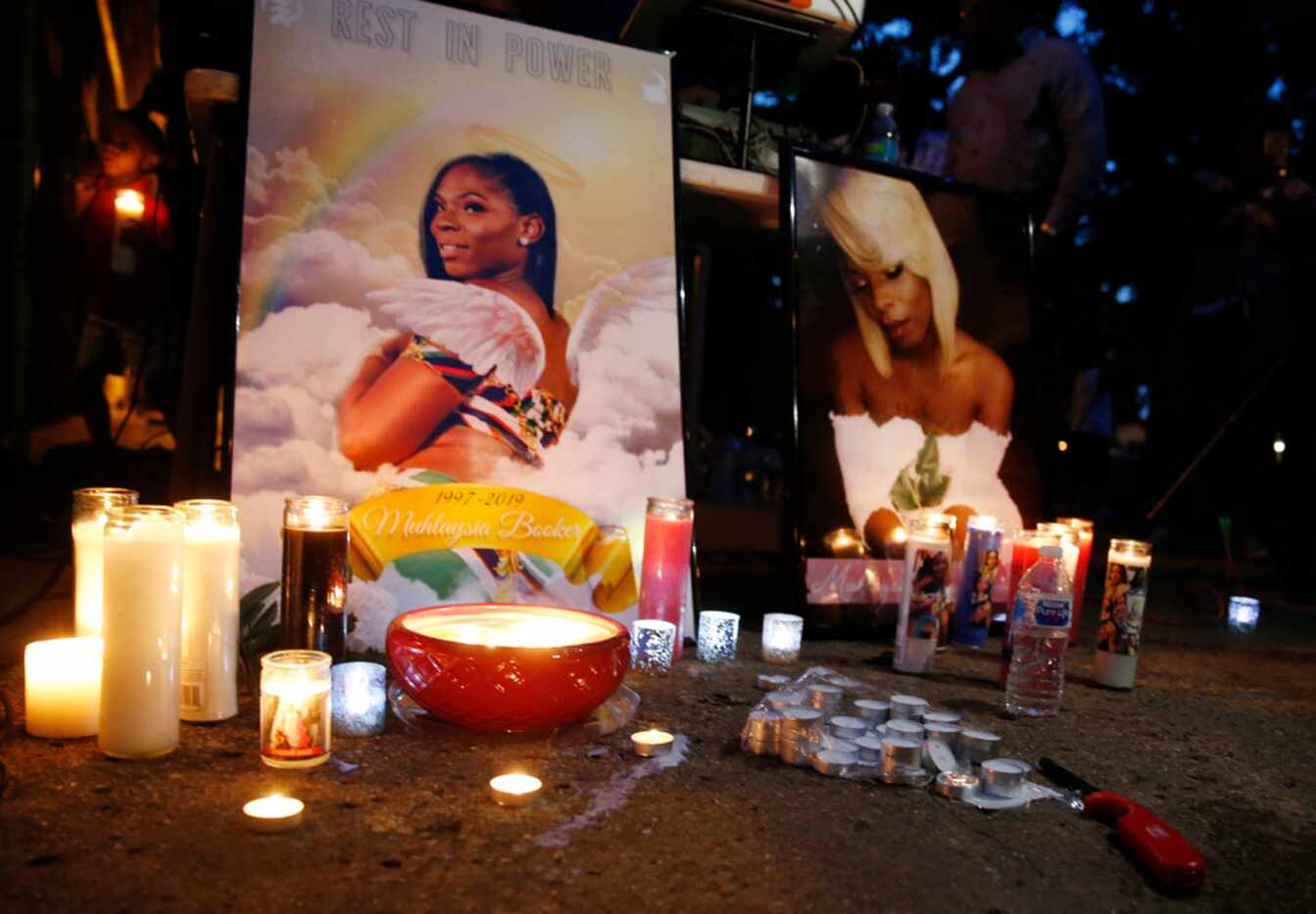 Candles surrounded photos of Muhlaysia Booker during a candlelight vigil in Dallas on May...