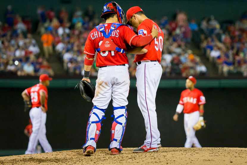 Texas Rangers relief pitcher Keone Kela gets a visit from catcher Robinson Chirinos after...