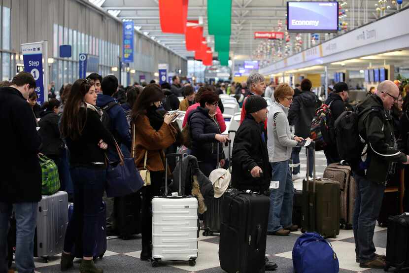 Travelers waited in line to check in for flights at O'Hare International Airport on Dec. 23...