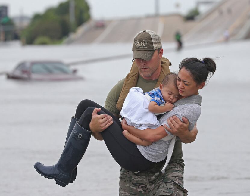 Houston SWAT officer Daryl Hudeck carried Catherine Pham and her 13-month-old son, Aidan, to...