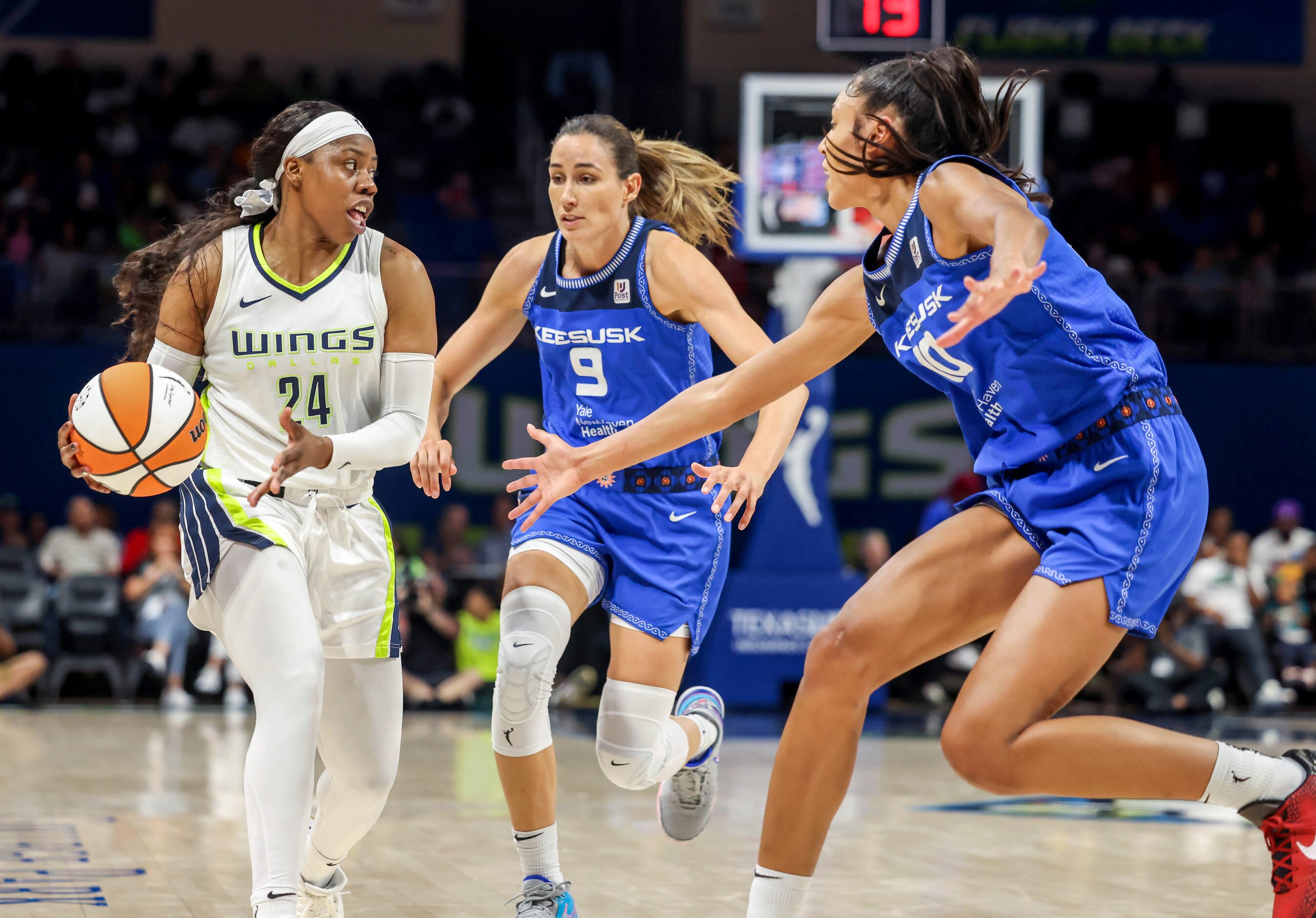 Dallas Wings guard Arike Ogunbowale (24) looks for an opening between Connecticut Sun guard...