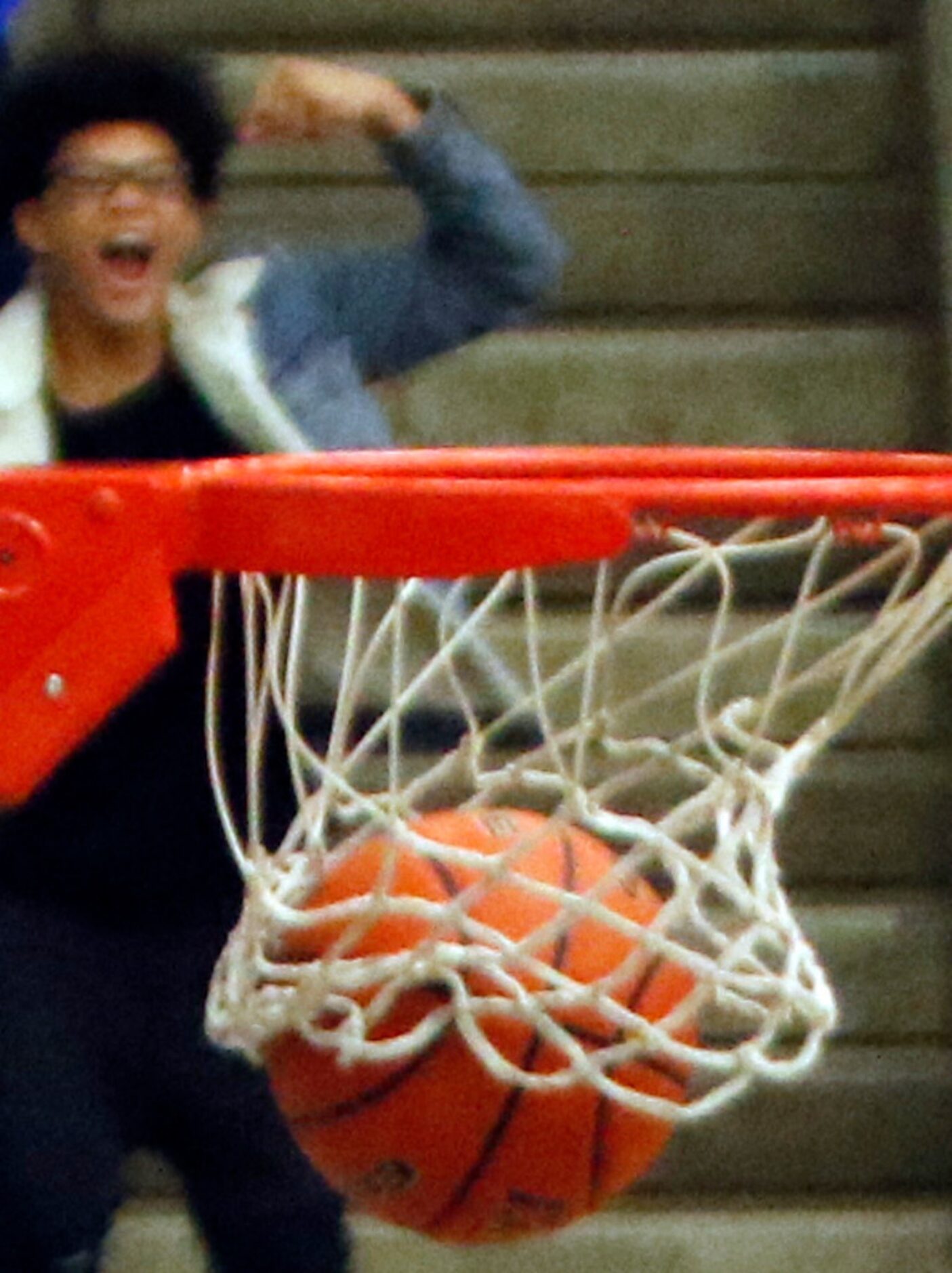 A fan in the upper deck cheers the dunk from Grand Prairie's Donald Ghostone (2) late in the...