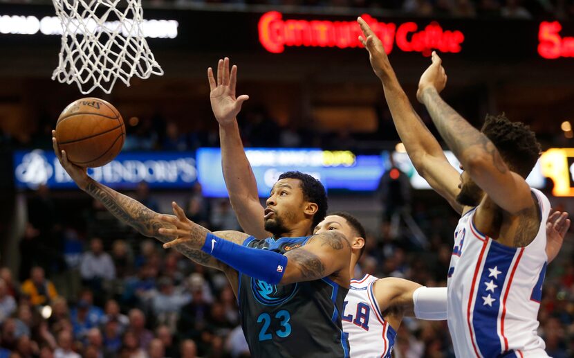 FILE - Mavericks guard Trey Burke (23) attempts a layup in front of Sixers guard Ben Simmons...