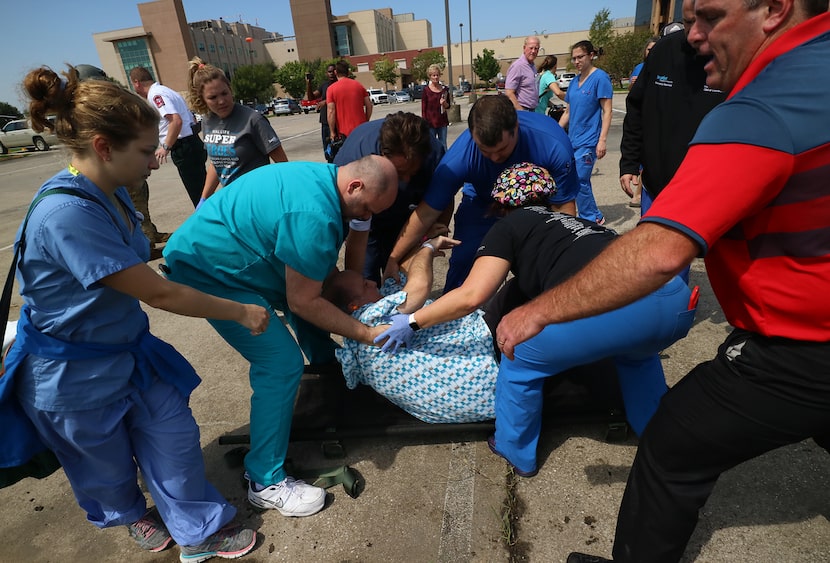 Baptist Hospital employees prepare patients waiting to be evacuated on Army Black Hawks...