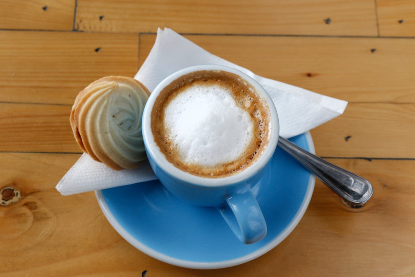 A cup of espresso macchiato servered with homemade nutella sugar cookie at Toasted Coffee +...