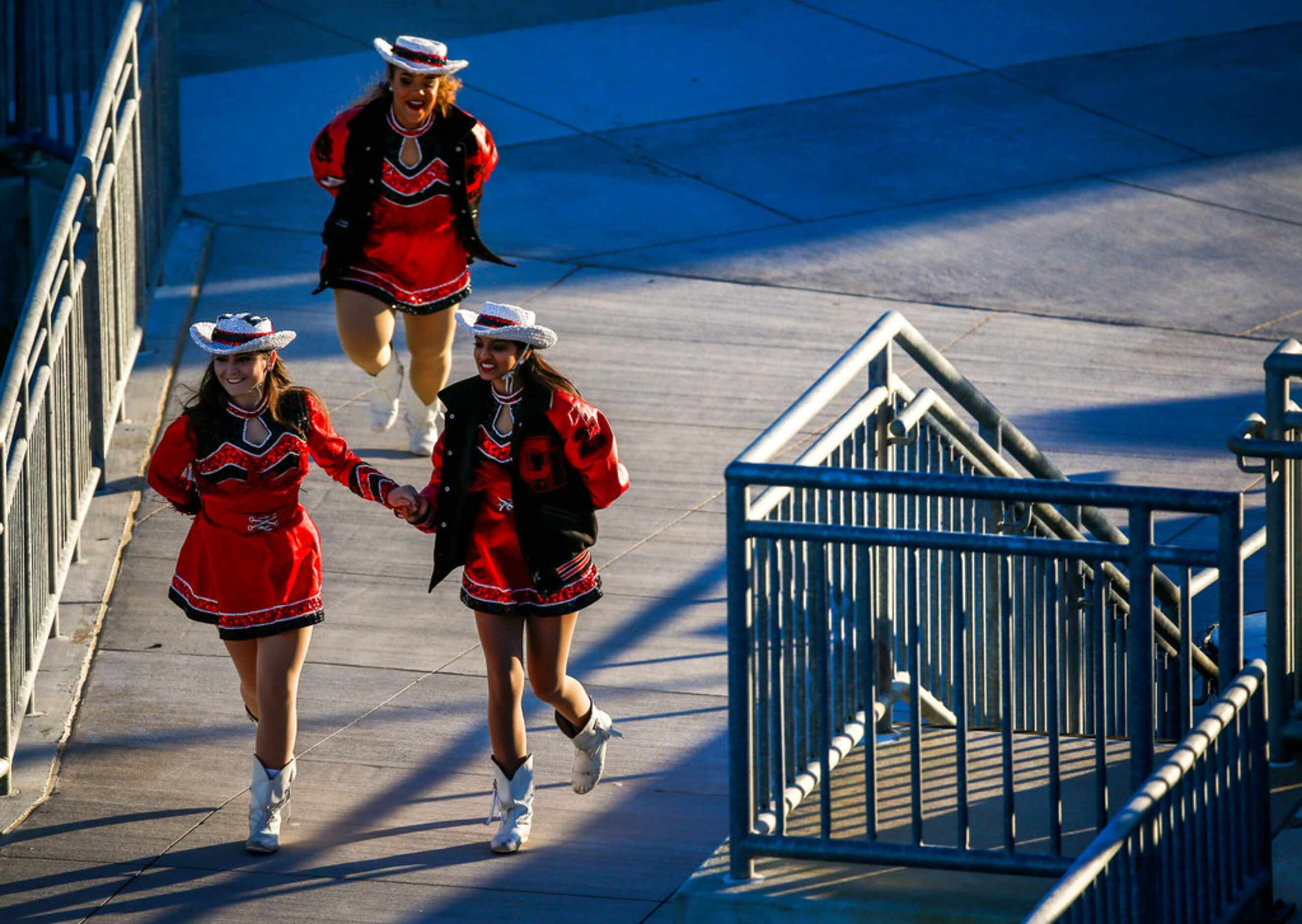 Colleyville Heritage cheerleaders race to the field prior to a high school football game...