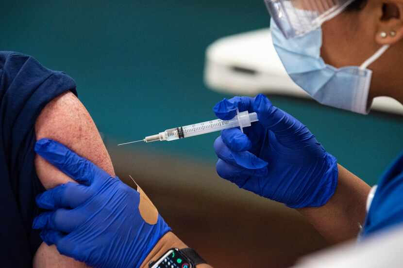 A registered nurse administers a COVID-19 vaccine in this file photo.