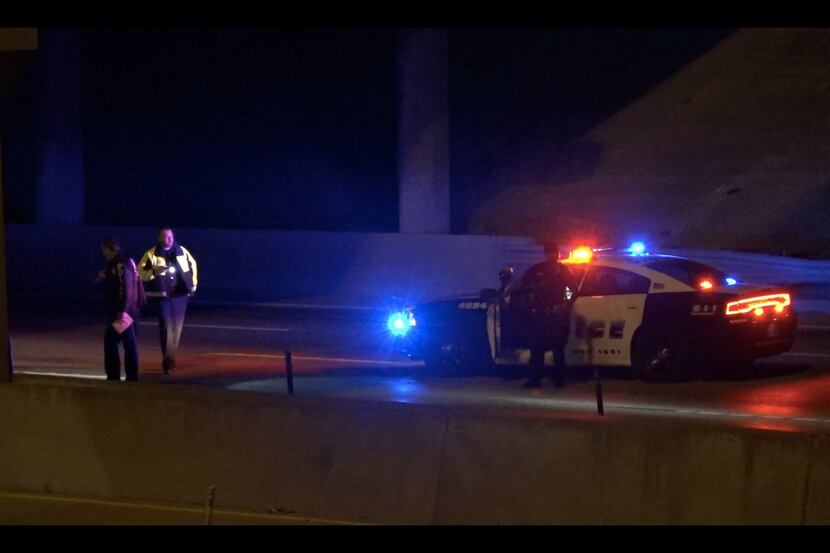 Dallas police investigate the area near where a woman was hit and killed by a passing truck...