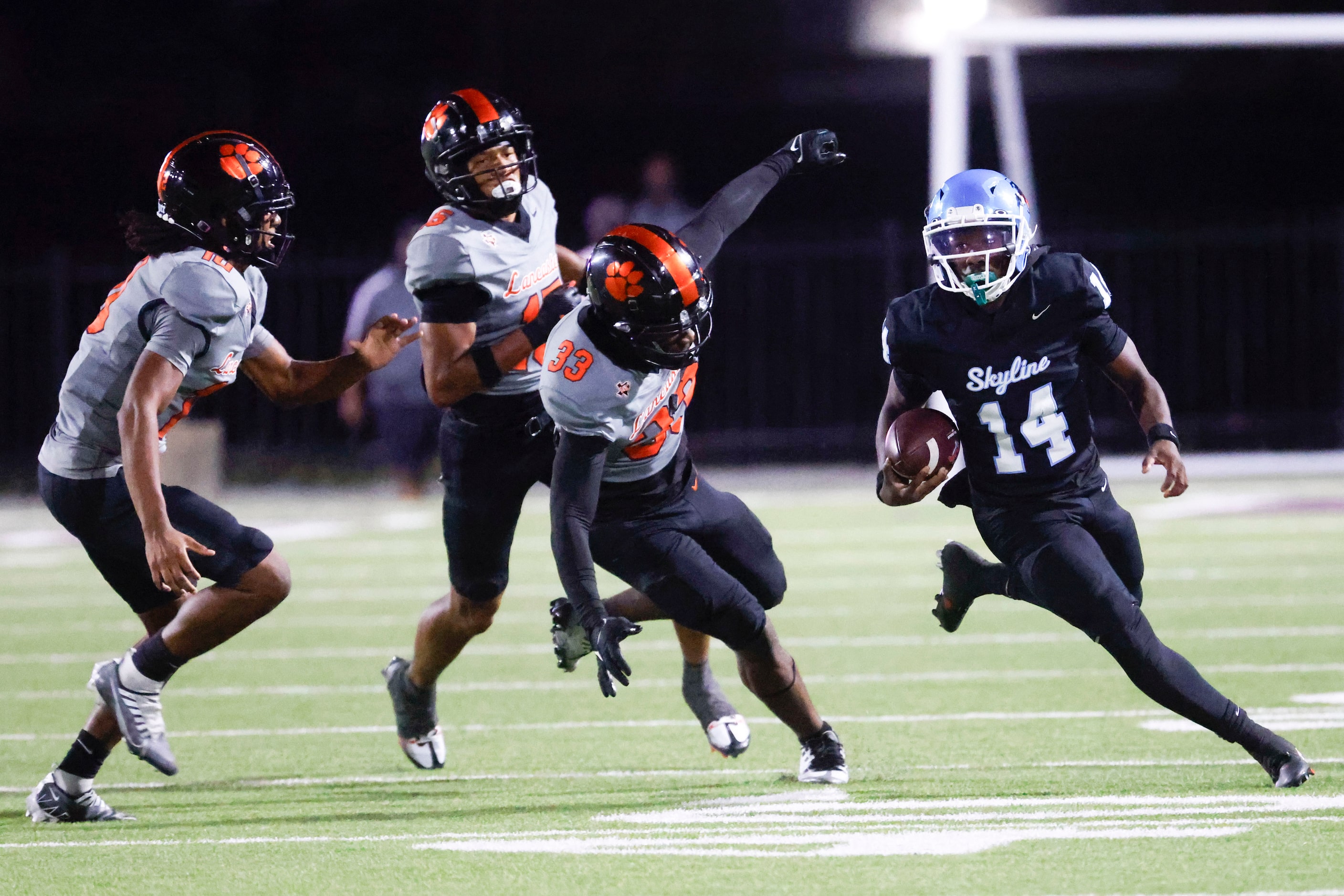 Skyline High’s Donta Ware (14) runs past Lancaster high’s defense line during the first half...